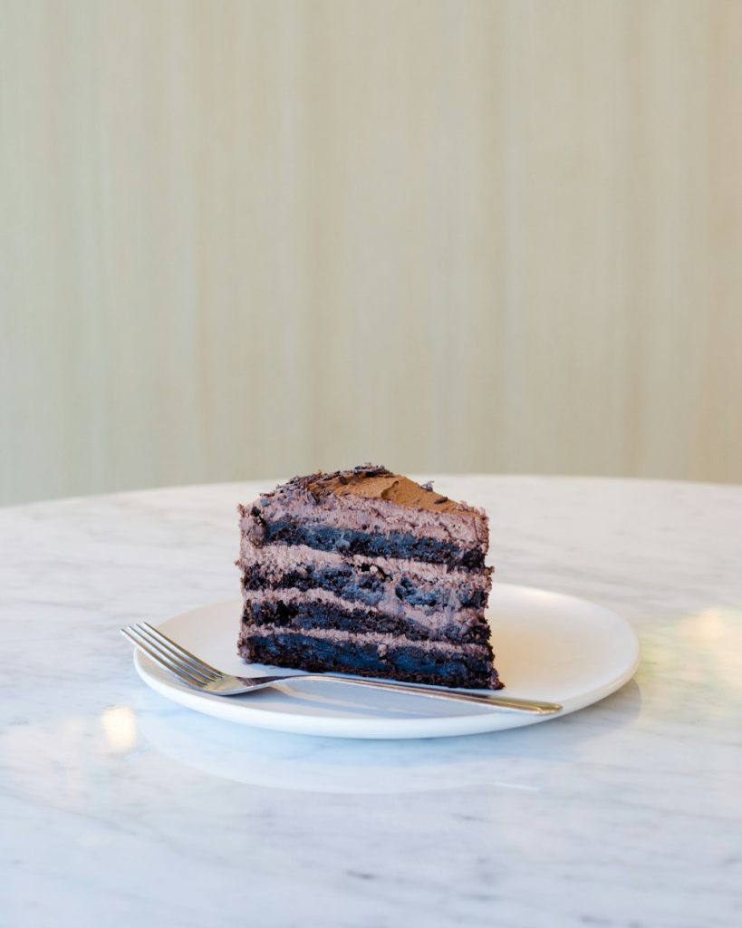 Slice of chocolate fudge cake with a fork on a plate
