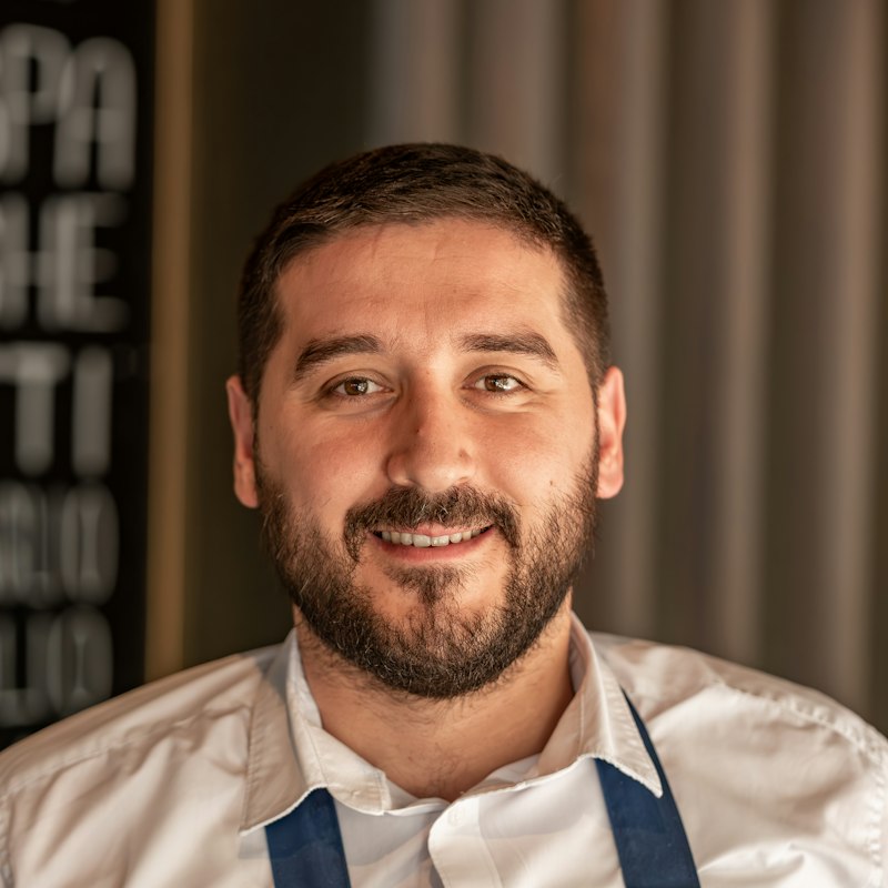 Smiling bearded baker in a blue apron